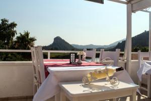 a table and chairs on a balcony with mountains in the background at Dalyan Terrace Hotel in Dalyan