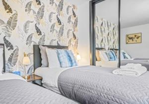 a bedroom with two beds and a mirror at Rothesay House by Klass Living Coatbridge in Coatbridge