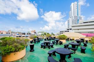 a patio with tables and benches in the water at Lamai Hotel in Patong Beach