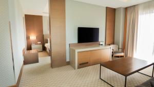a hotel room with a television and a living room at Motel Heksapolis in Tavşancıl