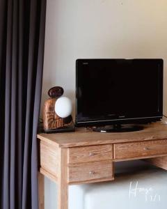 uma televisão num suporte de madeira com uma televisão em 11 House Mae rim by Kohei em Mae Rim