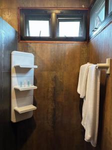 La salle de bains est pourvue de serviettes blanches et d'une fenêtre. dans l'établissement 11 House Mae rim by Kohei, à Mae Rim