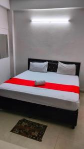 a bedroom with a large bed with red and white sheets at The Urban Villa in Noida +5 photos