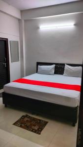 a bedroom with a large bed with red and white sheets at The Urban Villa in Noida
