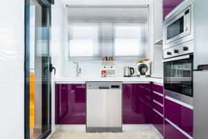 a kitchen with purple cabinets and a dishwasher at D.O.M.A. Residencial Alegria in Torrevieja +17 photos