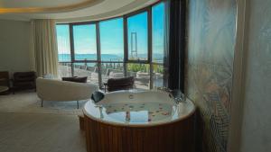 a bath tub in a room with a large window at HOTEL HEKSAPOLİS in Tavşancıl