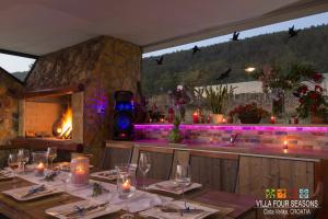 comedor con mesa y chimenea en Villa Four Seasons, heated pool and 3 en-suite bathrooms, en Velika Cista