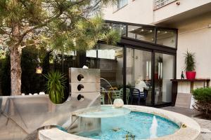 a house with a swimming pool in a yard at Garni Boutique Hotel Arta in Novi Sad