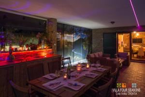 un restaurante con una mesa larga y un bar en Villa Four Seasons, heated pool and 3 en-suite bathrooms en Velika Cista