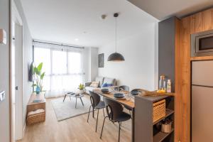 cocina y sala de estar con mesa y sillas en Be Casa - Valdebebas en Madrid