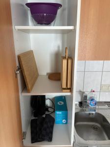 - une armoire avec un bol en violet et un évier dans l'établissement Gemütliches Ferienapartement, à Cassel