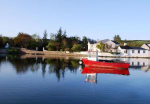 a red boat is sitting in the water at Seapoint Lodge in Westport