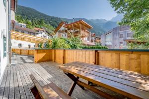 una terraza de madera con un banco de madera encima en Haus Alpenblick, en Oetz