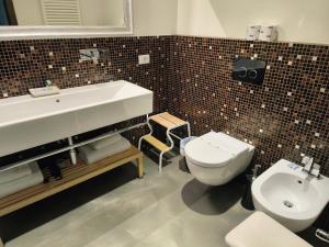 La salle de bains est pourvue d'un lavabo blanc et de toilettes. dans l'établissement Villa Le Statue, à Florence