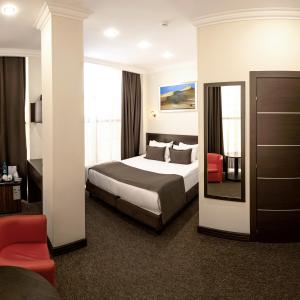 una camera d'albergo con letto e specchio di ZhanaOtel Hotel ad Aqtau