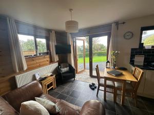 a living room with a couch and a table at Swansea Log Cabin in Pontardawe