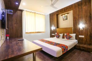 1 dormitorio con 1 cama grande y pared de madera en FabHotel MNG en Kānpur