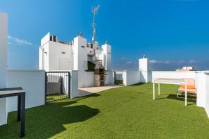 a balcony with green grass on a white house at D.O.M.A. Residencial Alegria in Torrevieja