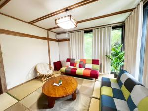 ein Wohnzimmer mit einem Sofa und einem Tisch in der Unterkunft シークレットベースゆふいん in Yufu