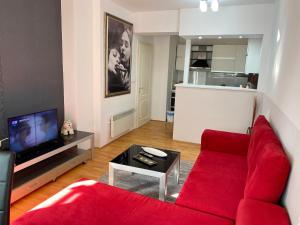 a living room with a red couch and a tv at Apartment Alex in Ohrid