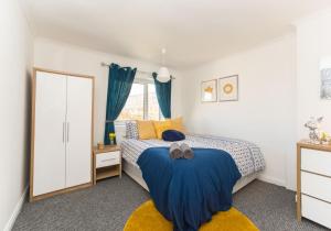 a bedroom with a bed with a blue blanket at Kenmar House by Klass Living Hamilton in Hamilton