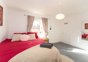 a bedroom with a large red bed with a window at Kenmar House by Klass Living Hamilton in Hamilton