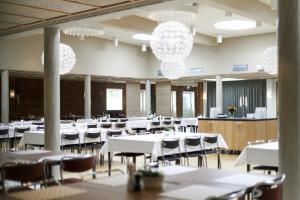 a banquet hall with white tables and chairs and chandeliers at STF Hotell Rum Oscar in Oskarshamn