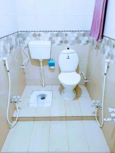a bathroom with a white toilet and a sink at Galaxy Inn in Karachi