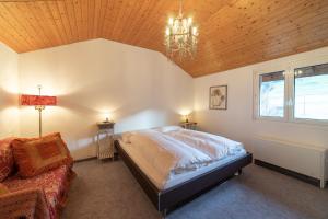 a bedroom with a large bed and a chandelier at Lisa in Wildhaus