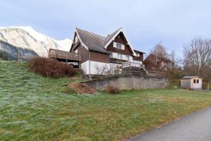 uma casa numa colina com montanhas ao fundo em Lisa em Wildhaus