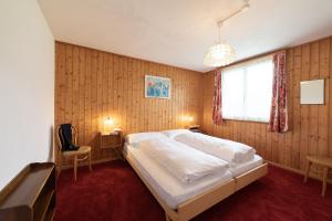 a bedroom with a large white bed and a window at Sonnhalde in Wildhaus