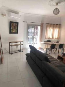 a living room with a couch and a table at joli appart 2 chambres salon liberté 6 extension in Dakar