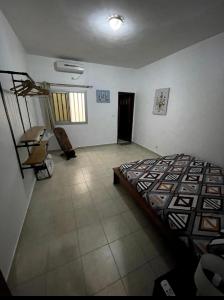 a bedroom with a bed and a desk in it at joli appart 2 chambres salon liberté 6 extension in Dakar