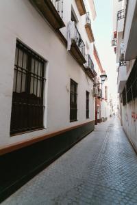 an empty street in an alley between buildings at One & Lux Casa Maravilla in Seville