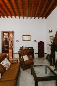 塞維利亞的住宿－One & Lux Casa Maravilla，客厅配有皮革家具和钢琴