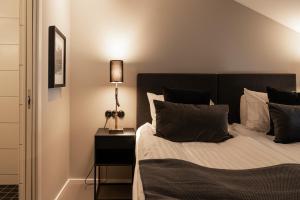 ein Schlafzimmer mit einem Bett und einer Lampe auf einem Nachttisch in der Unterkunft Marstrands Kurhotell in Marstrand