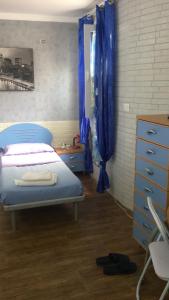 布林迪西的住宿－Villa Susanna，一间卧室配有床和蓝色窗帘的窗户