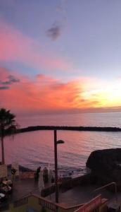 een zonsondergang boven de oceaan met zonsondergang bij Apartamento 1 vista mar, Las Américas, Costa Adeje, sx in Playa de las Americas