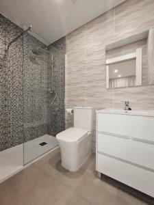 a bathroom with a toilet and a shower and a sink at Apartamento 1 vista mar, Las Américas, Costa Adeje, sx in Playa de las Americas