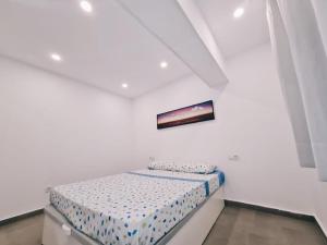 een kleine slaapkamer met een bed in een witte kamer bij Apartamento 1 vista mar, Las Américas, Costa Adeje, sx in Playa de las Americas