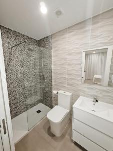 a bathroom with a toilet and a shower and a sink at Apartamento 1 vista mar, Las Américas, Costa Adeje, sx in Playa de las Americas
