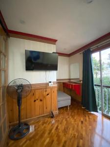 a living room with a fan and a television on the wall at Casa Valle Verde in Baguio