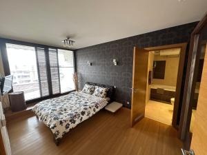 a bedroom with a bed and a large window at Silver city in Sofia