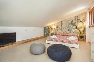 a bedroom with a bed and two ottomans at Villa dell'Artista in Scopello