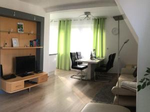 a living room with a television and a table with chairs at Haus Burgblick in Badenweiler