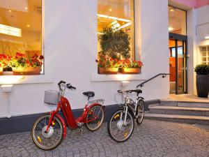 dos bicicletas estacionadas frente a un edificio con flores en Mercure Epinal Centre, en Épinal