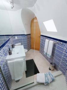 a bathroom with a white sink and blue tiles at Idaira Paradise in Playa Paraiso