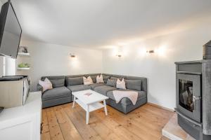 sala de estar con sofá y chimenea en Haus Alpenblick, en Oetz