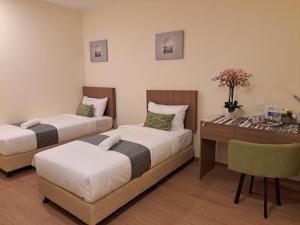 a hotel room with two beds and a desk at SCC HOTEL PJ in Petaling Jaya