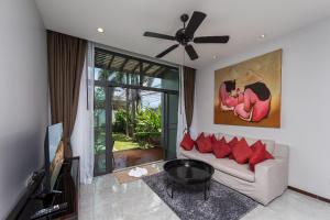 a living room with a couch and a tv at VILLA ATA | Private Pool | Saiyuan Estate by Tropiclook | Nai harn beach in Nai Harn Beach
